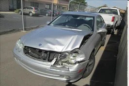 Silver Mercedes with front-end crash damage, before repair
